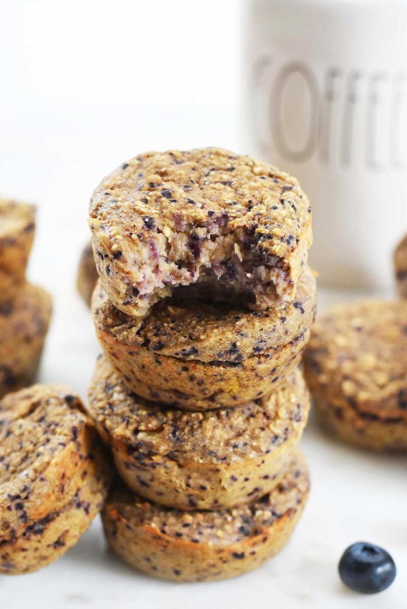 4 Ingredient muffins are stacked 4 high. The top muffin has a bite taken out of it. 