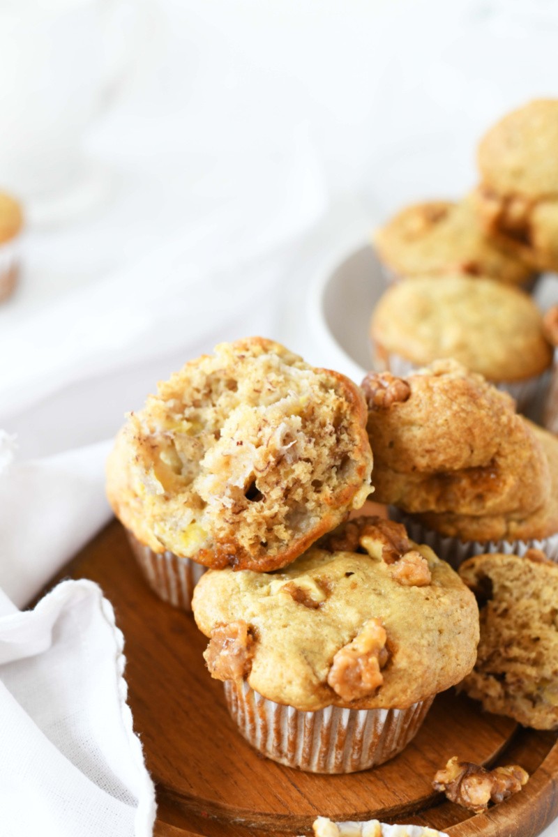 Banana Bread Muffins muffin top on a plate of muffins.