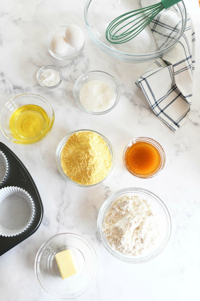 Jumbo corn muffins ingredients on a white marble table with a blue patterned napkin.