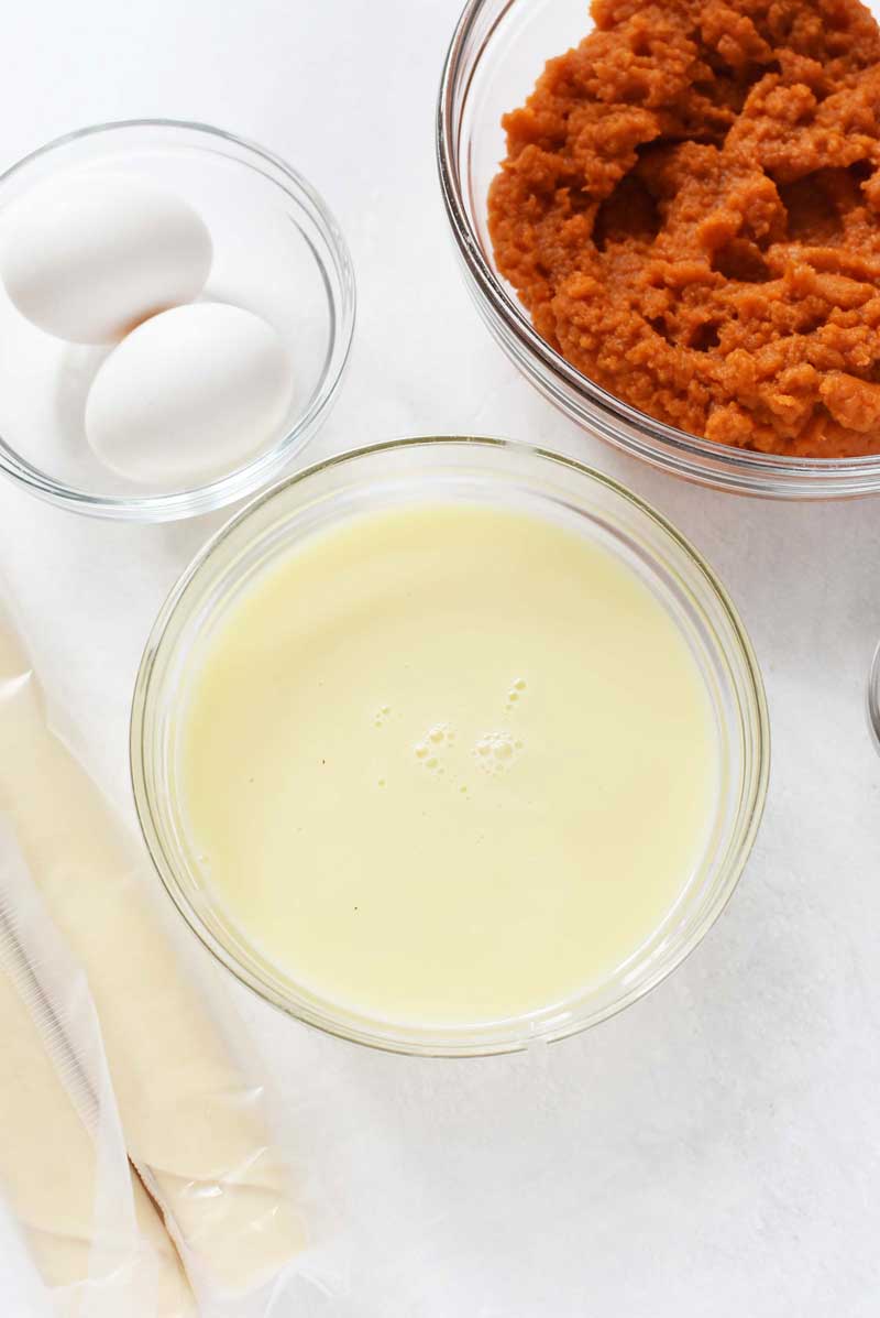 Muffin Tin ingredients are in glass bowls with marble table top.