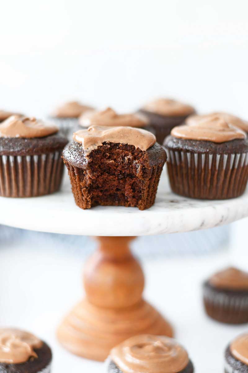 Chocolate Mayonnaise Frosted cupcakes. These cupcakes are on a wood and marble cakestand.  