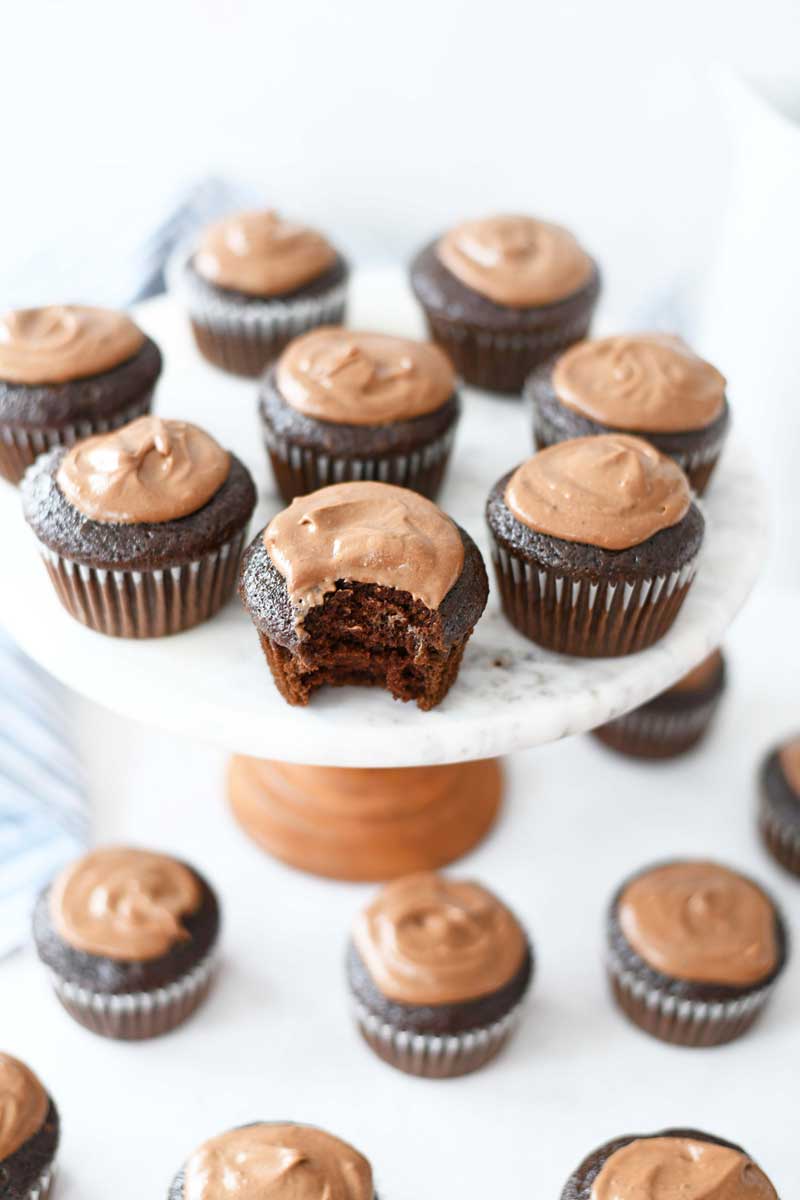 Chocolate mayonnaise cupcakes with cocoa frosting on a white marble cake stand. 