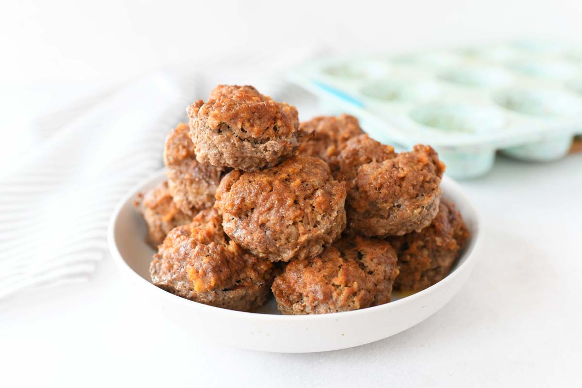 Mini Muffin Pan Meatloaf. These are all on a white plate with a blue muffin pan in the background.