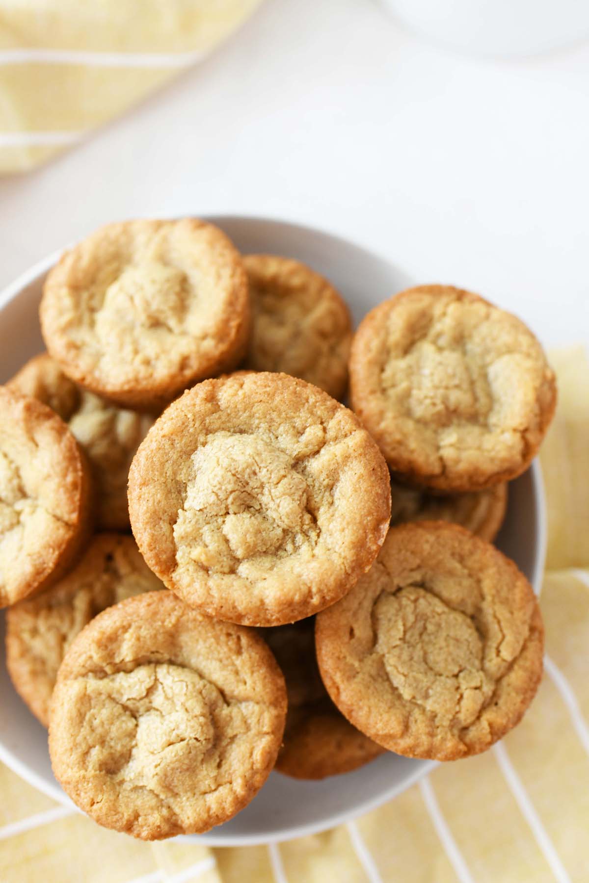 Muffin Tin Peanut Butter Brownie Recipe on a white plate with a yellow napkin nearby.