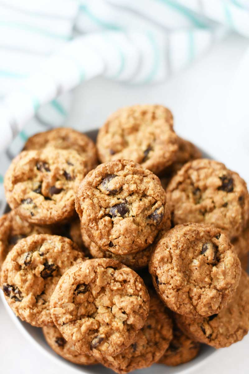 Oatmeal Raisin Cookies are golden brown in a white dish up close.