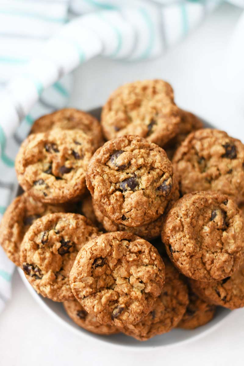 Oatmeal Raisin Cookies Made in a Muffin tin. These cookies are stacked in a white bowl.