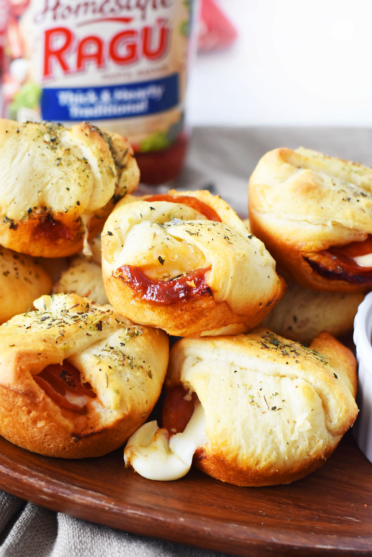 Pepperoni Cheese Bites- Baked golden-brown and loaded with warm pepperoni and cheese. There is a Ragu jar in the background.