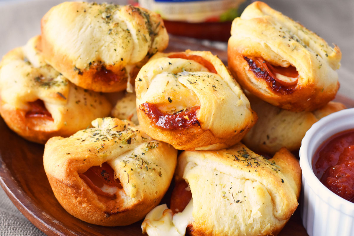 Pepperoni Crescent Bites re on a wooden plater.