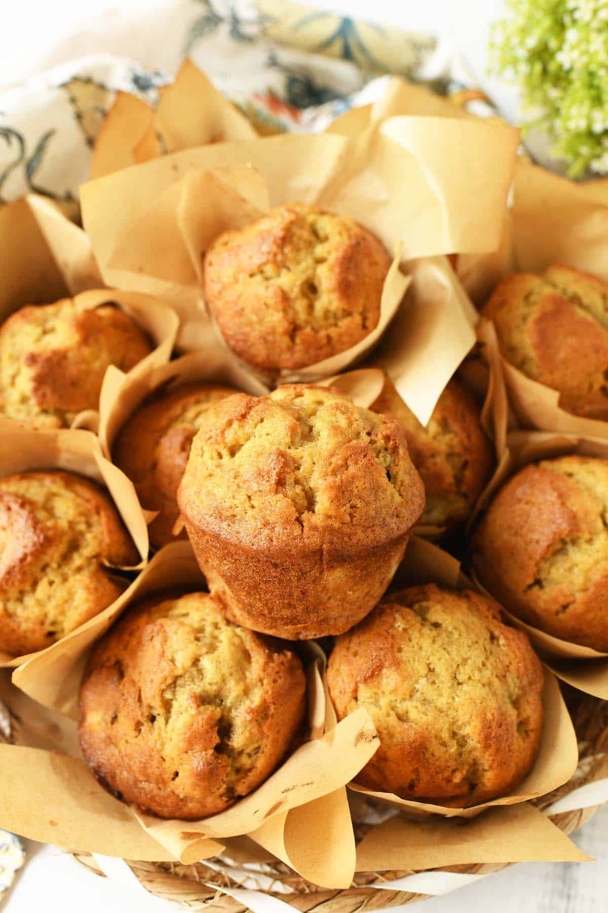 Banana Nut Muffins in a basket with neutral muffin liners.