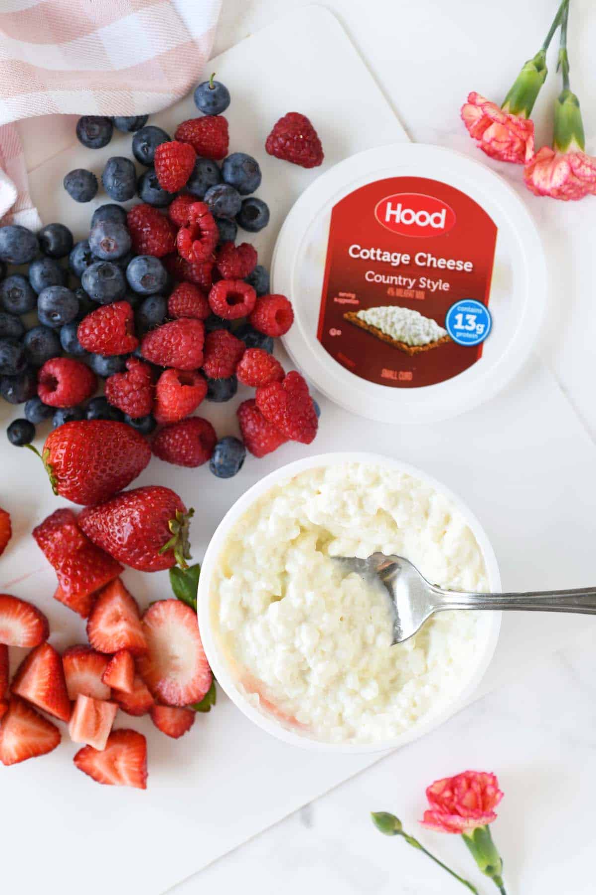 Fresh berries and Hood cottage cheese on a white table.