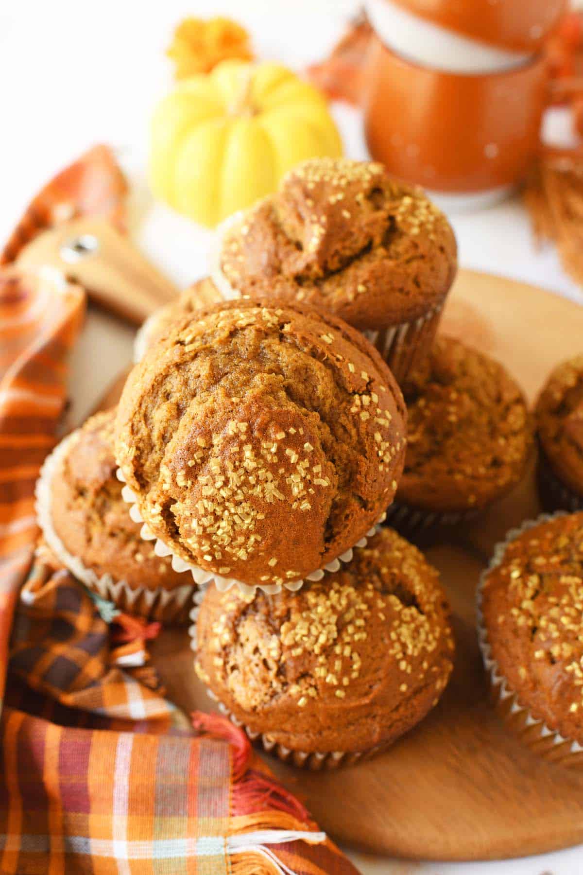An up-close stacked jumbo muffin on a wooden tray with fall decor.